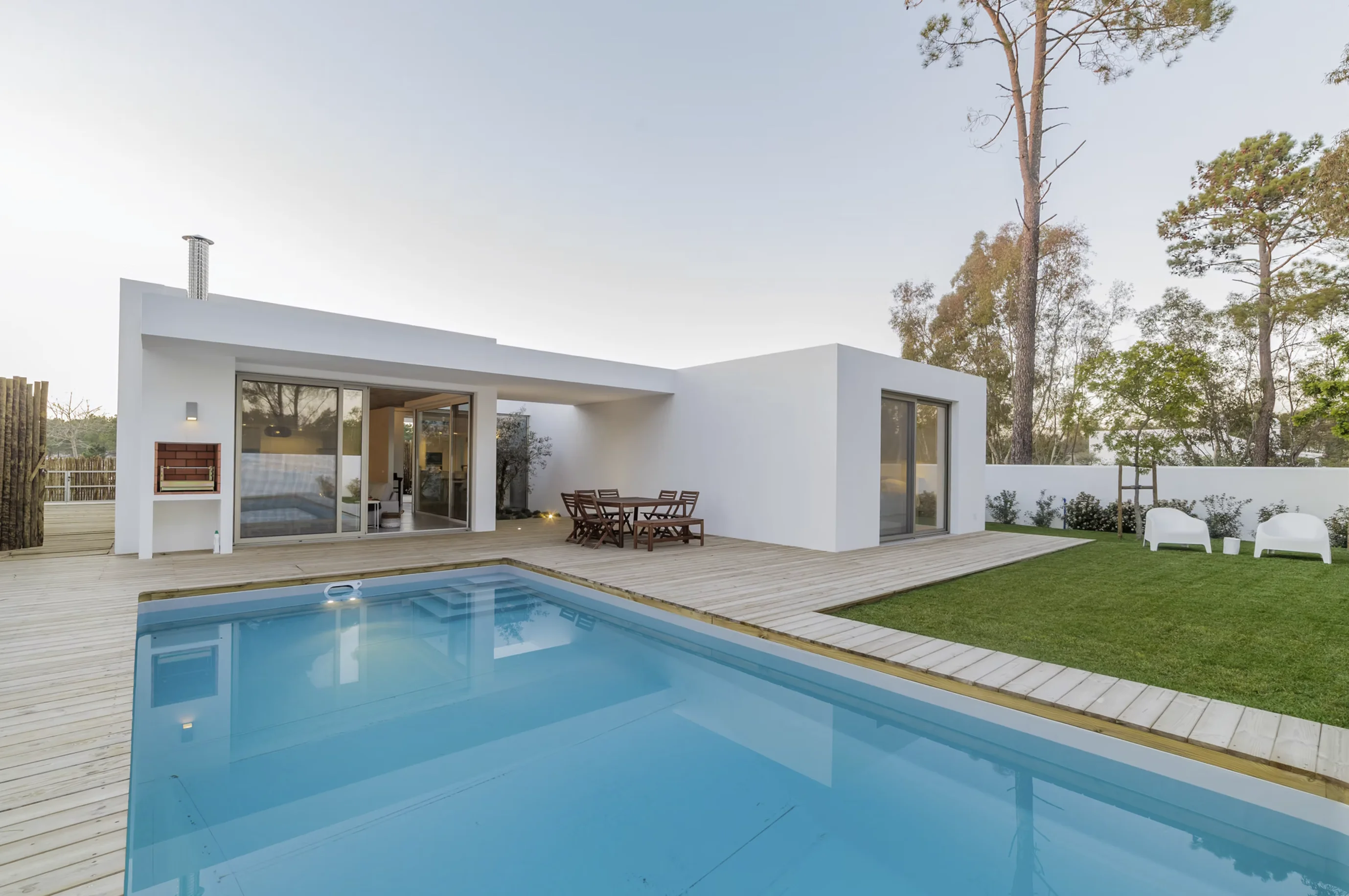 Modern single-story house and swimming pool beside a lawn